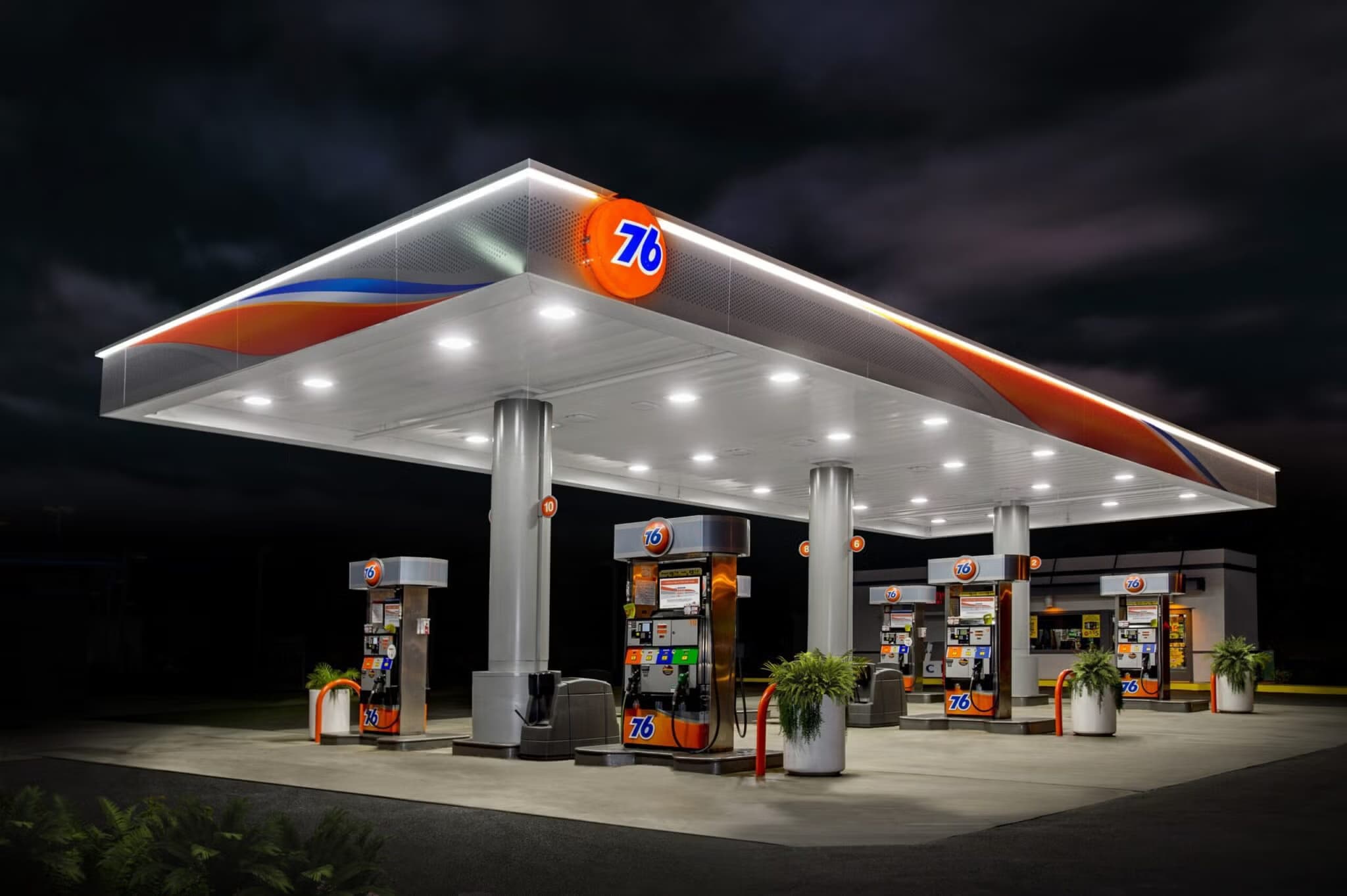 A 76 station canopy lit up at night.